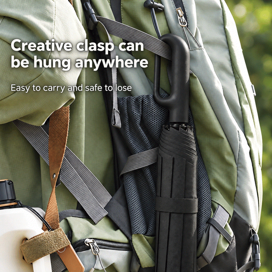 Automatic Folding Umbrella in black with a creative clasp hanging from a green backpack strap, compact and portable design