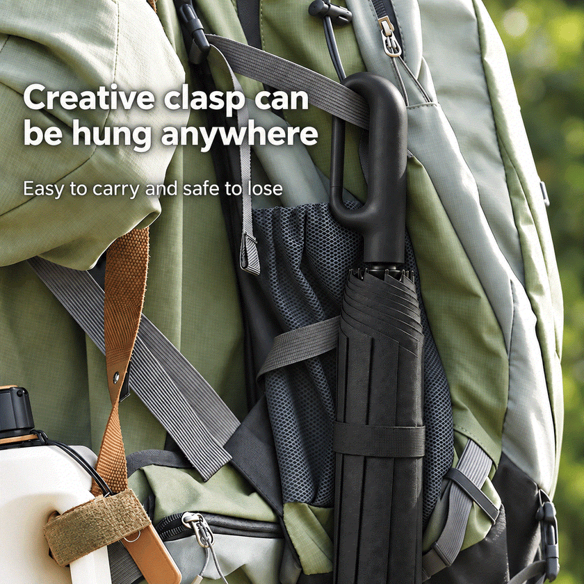 Automatic Folding Umbrella in black with a creative clasp hanging from a green backpack strap, compact and portable design