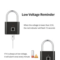Smart Fingerprint Padlock in black with silver shackle, USB charging cable connected to the lock, showing low voltage reminder feature with red indicator light